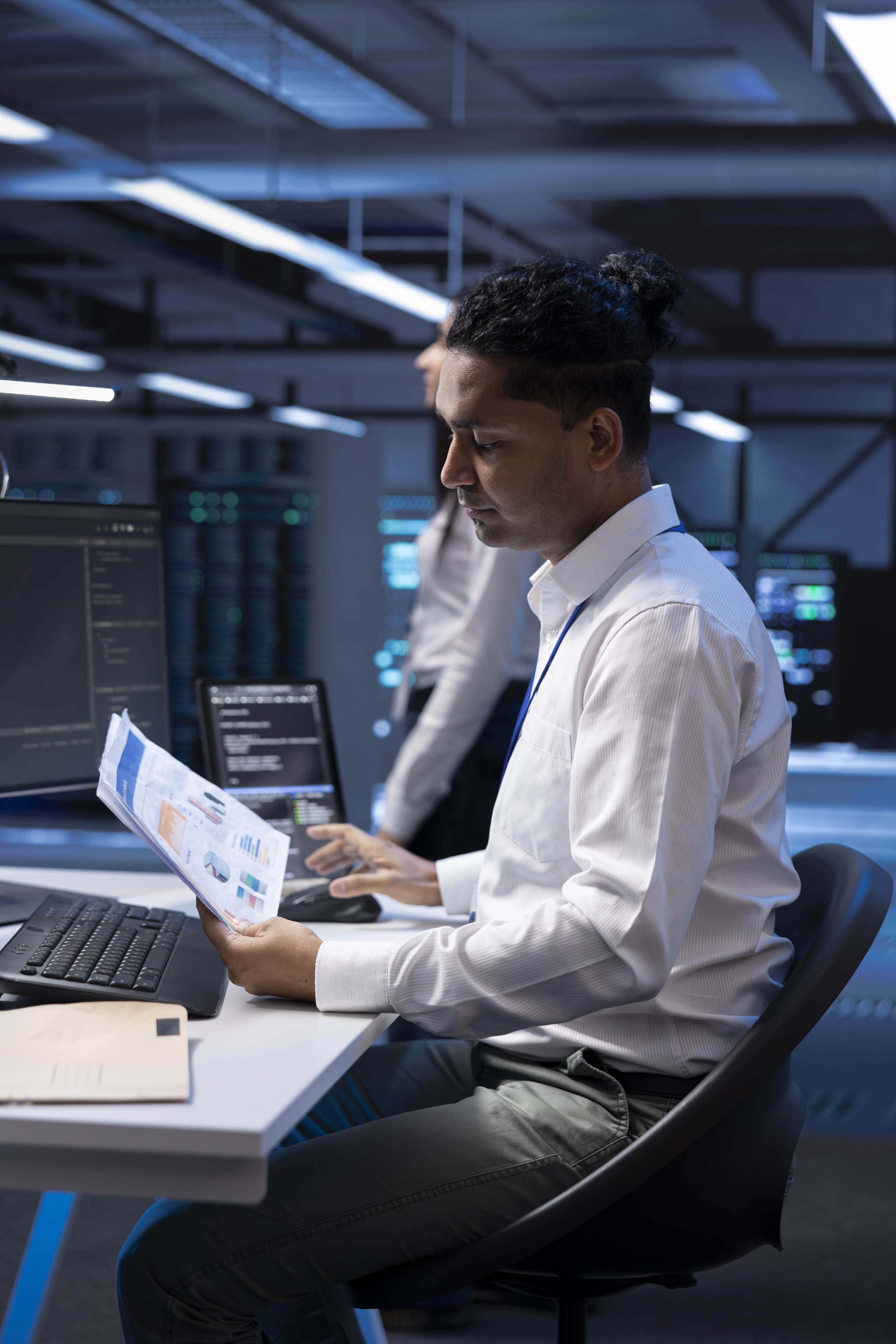 Especialista revisando documentación en sala de servidores